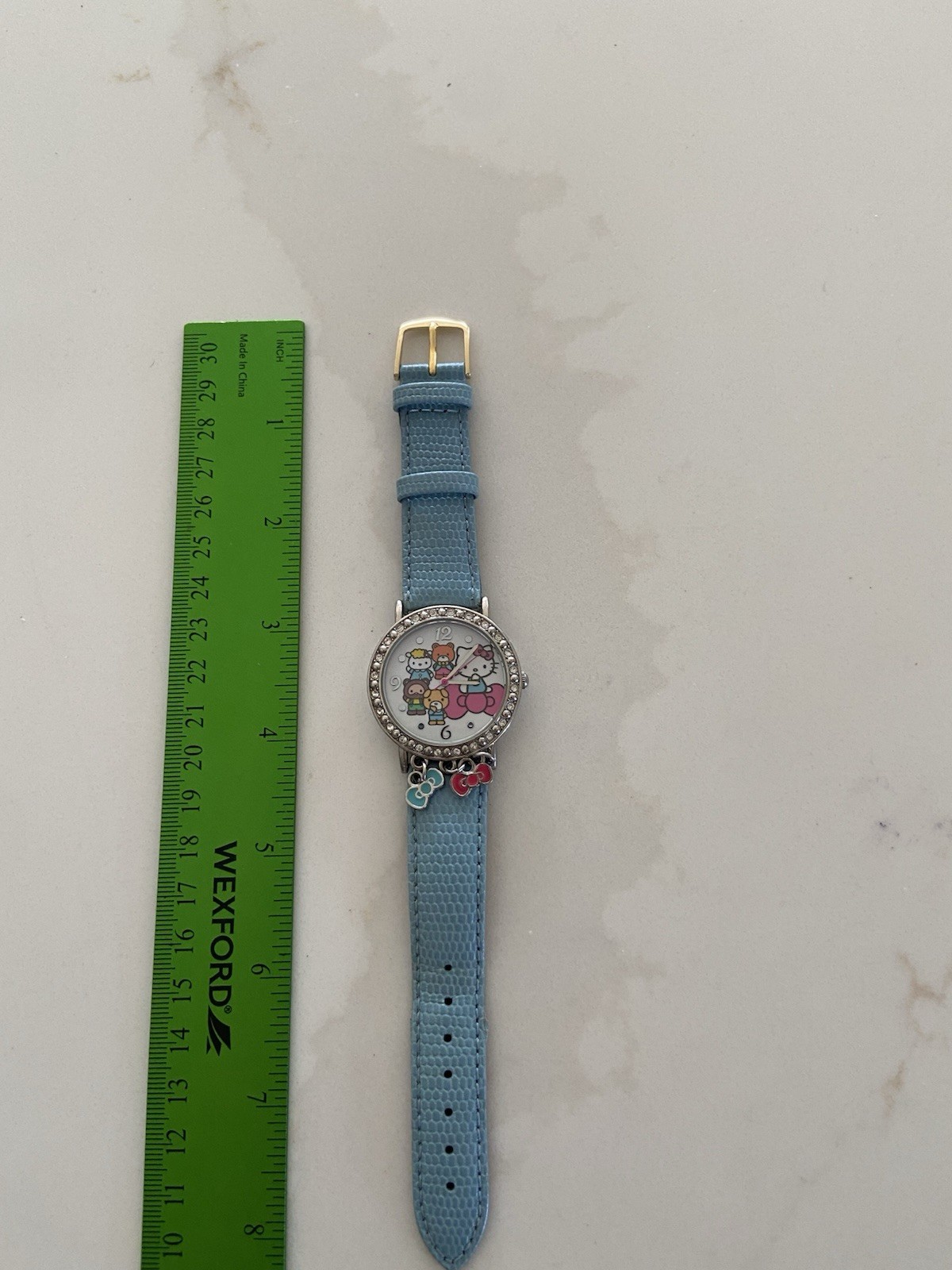 Hello Kitty watch with a light blue faux leather strap and rhinestone bezel Runs