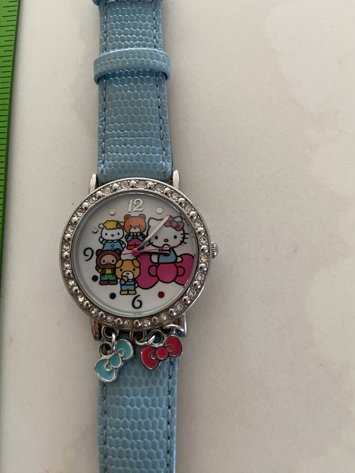 Hello Kitty watch with a light blue faux leather strap and rhinestone bezel Runs