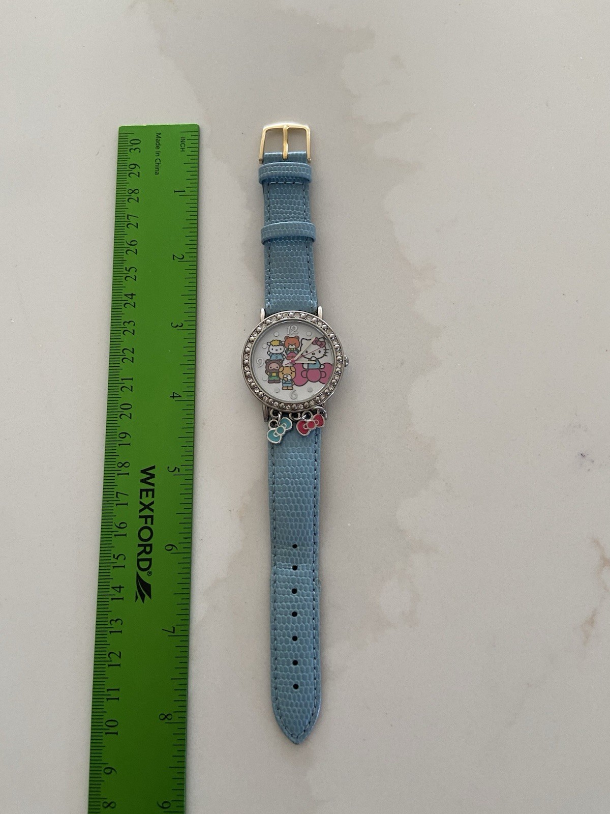 Hello Kitty watch with a light blue faux leather strap and rhinestone bezel Runs